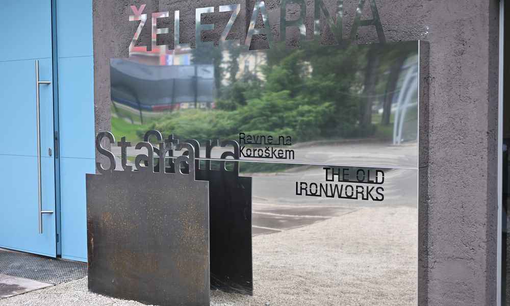 Reflektiven napis \"Stara železarna Ravne na Koroškem, The Old Ironworks\"