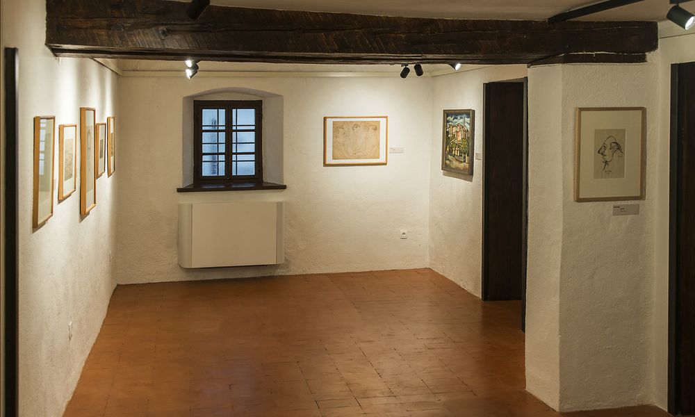 Razstavni prostor v galeriji z obešenimi umetninami