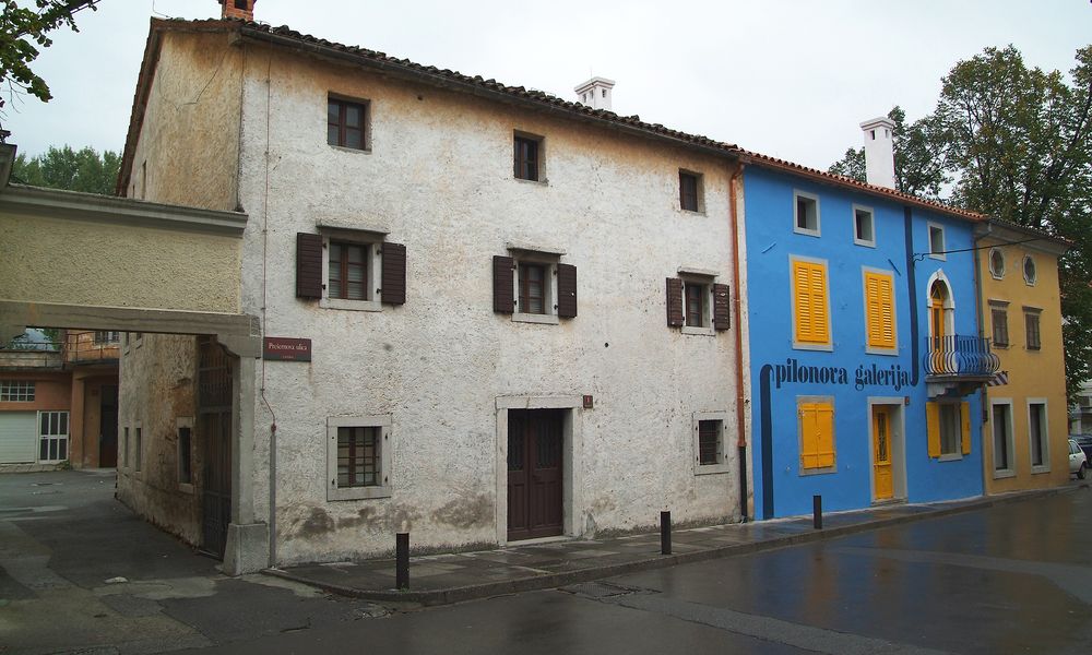 Zunanji pogled na stavbo galerije pred prenovo, desno se stavbe držijo ostali prostori Pilonove galerije